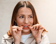 Patient putting on clear aligner in treatment room