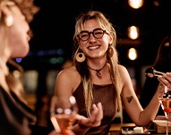 Friends smiling while enjoying meal together