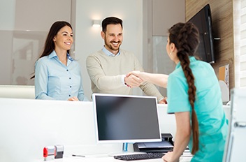 Dental patient shaking hands with dental team member