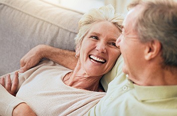 Older couple smiling on couch