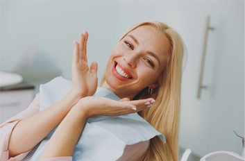 Young woman in yellow blouse smiling in dental chair