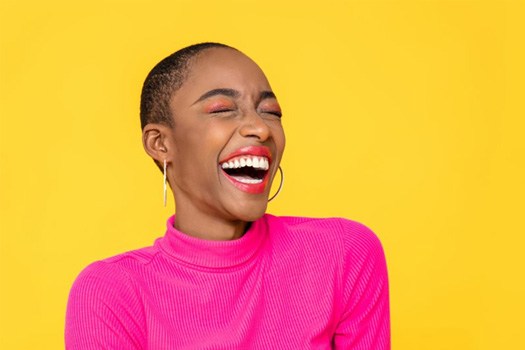 Woman smiling brightly on a yellow background