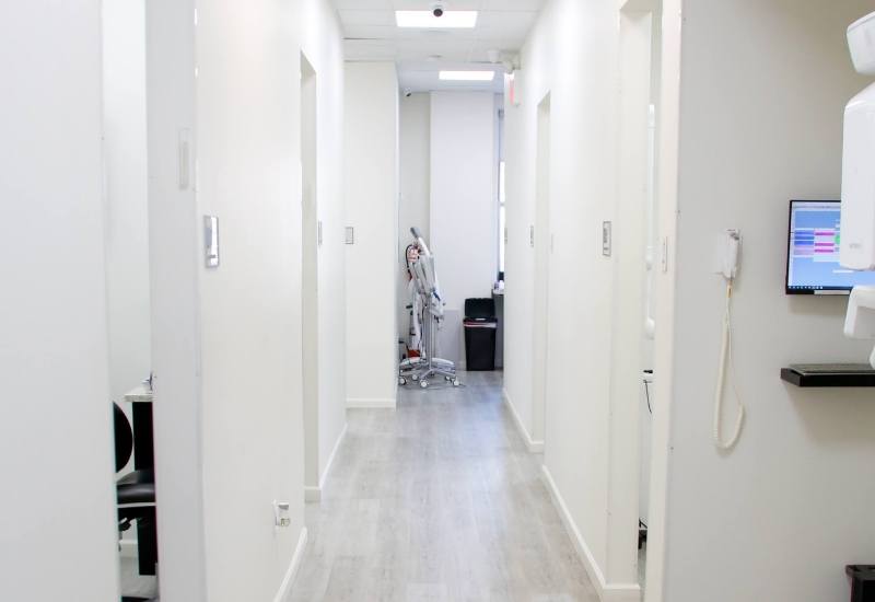 White hallway branching off into different dental treatment rooms