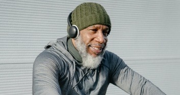 Older man wearing headphones and green beanie