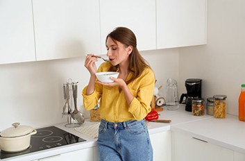 Woman eating soup while recovering from wisdom tooth extractions