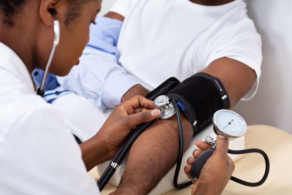 Medical professional taking a man's blood pressure with arm cuff